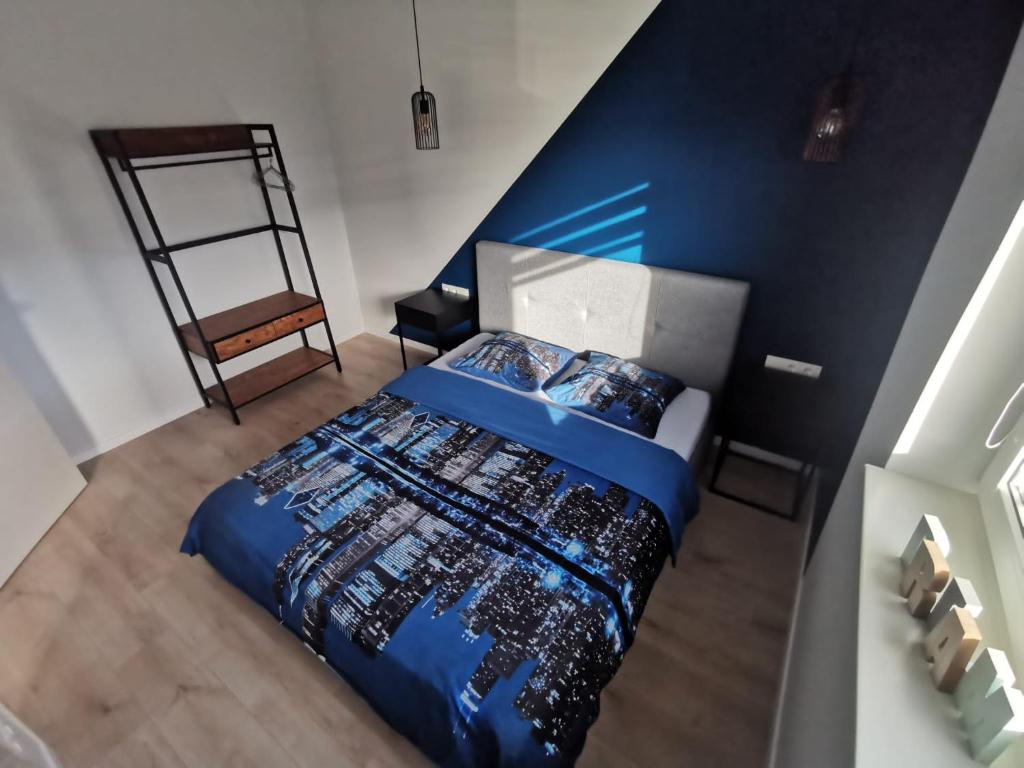 1 dormitorio con cama y pared azul en K-Town - Apartments ViaBaltic Kaunas en Kaunas
