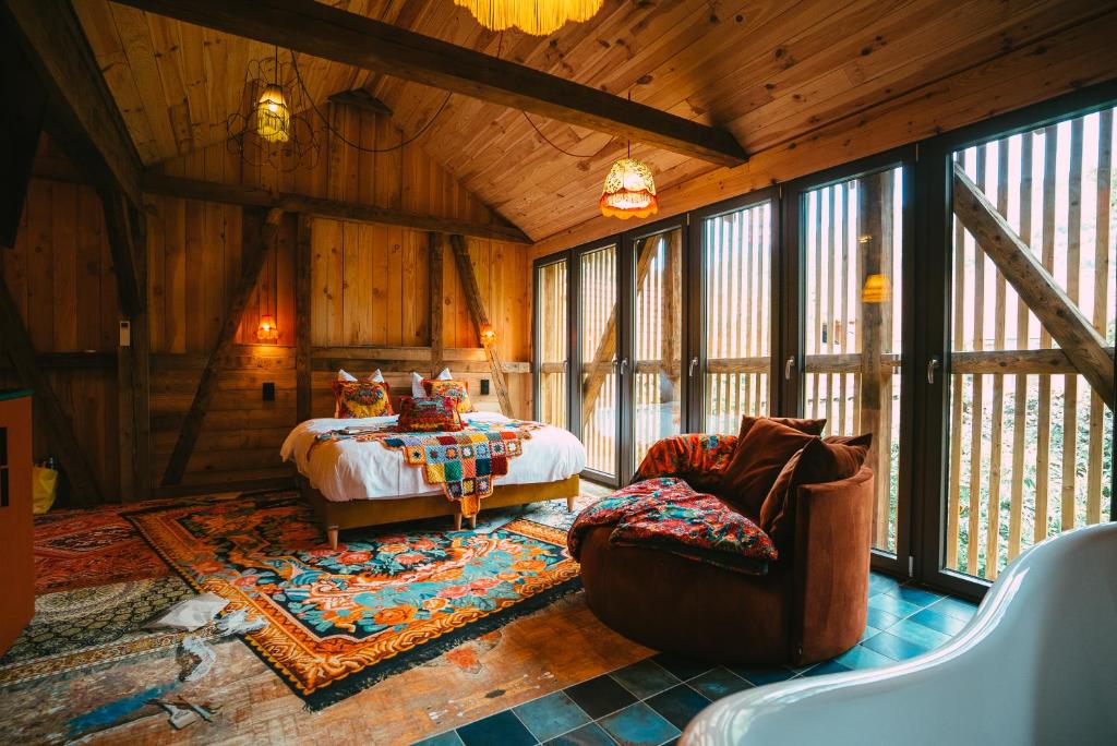een slaapkamer met een bed en een bank in een kamer bij Domaine Bohème I art de vivre in Guebwiller