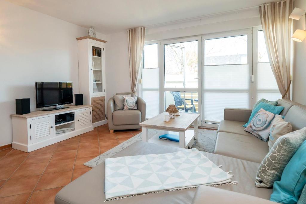 - un salon avec un canapé et une télévision dans l'établissement Residenz am Strand Wohnung 2-28, à Zingst