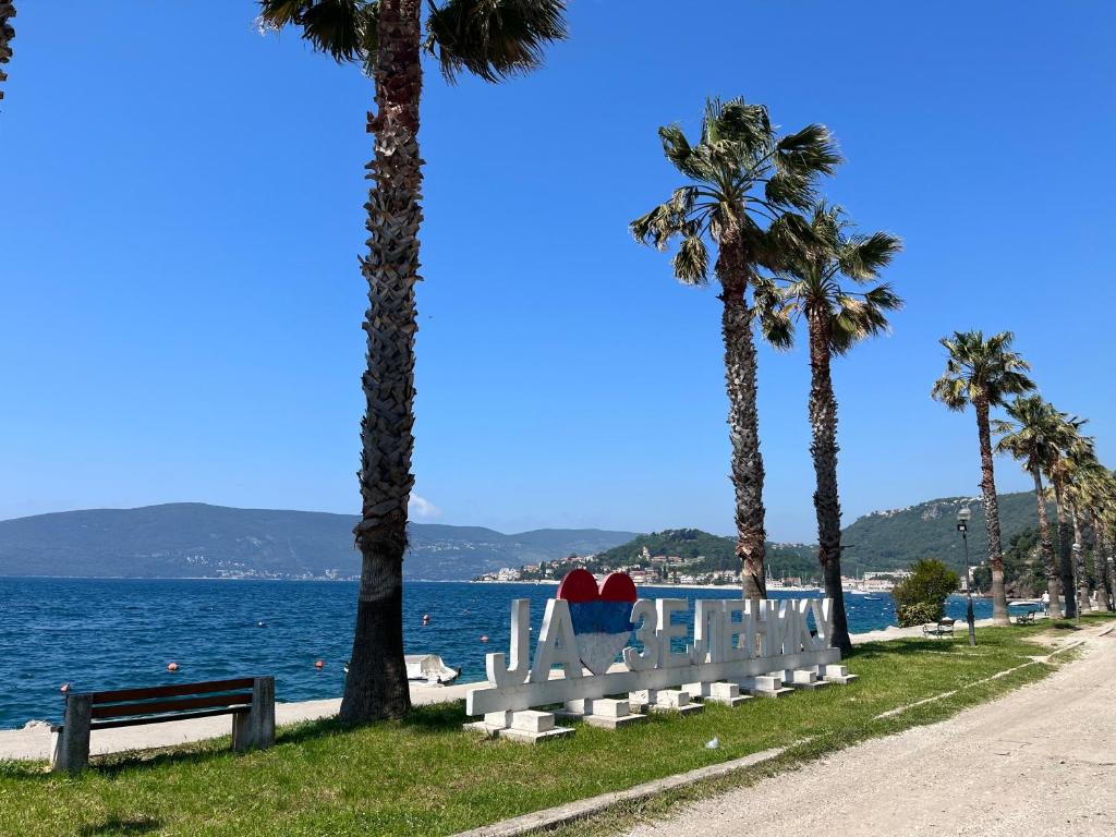 a white bench with two hearts on it next to the water at Apartment’s Maric - Zelenika,Herceg Novi in Zelenika