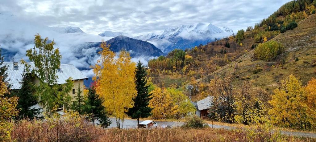 a house in a valley with mountains in the background at Studio Uissan pour 5 personnes à côté des pistes in LʼHuez