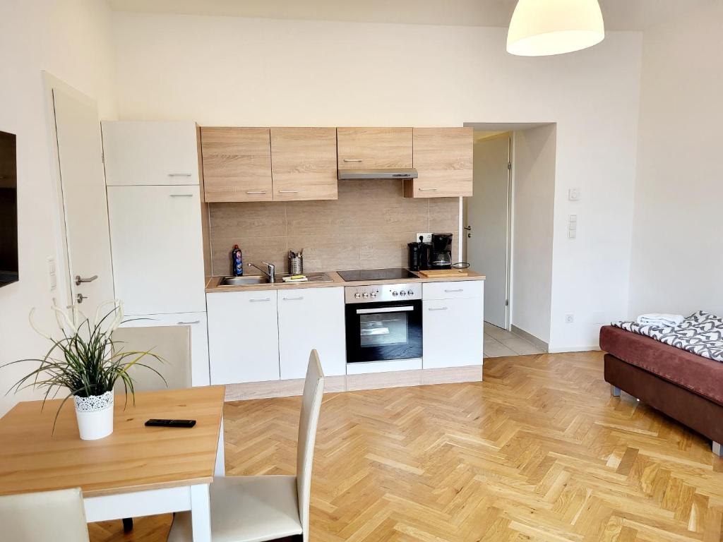 een keuken en woonkamer met een tafel en een bank bij Buchengasse Apartment Vienna - Free Highspeed-Internet in Wenen