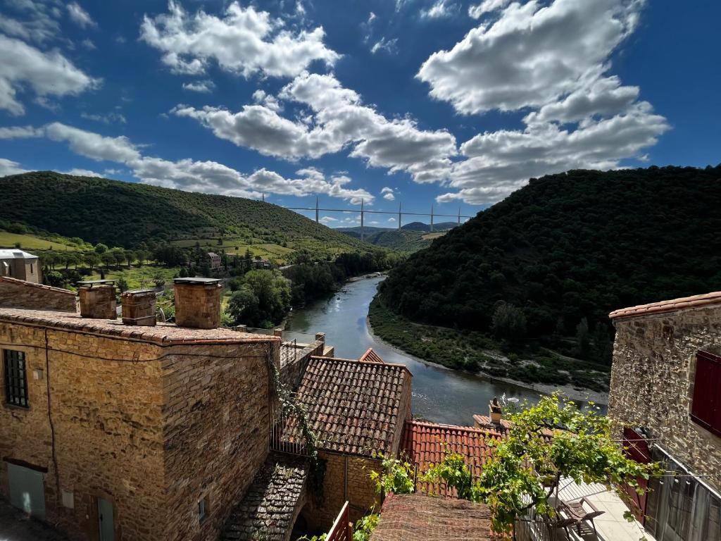 a view of a river between two buildings at Les Roches in Comprégnac