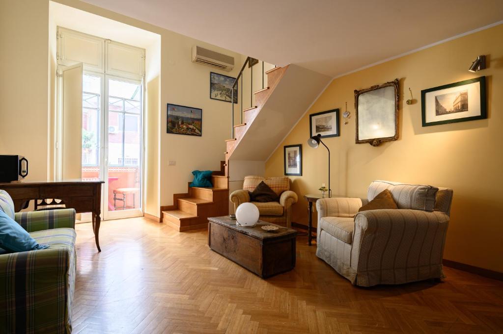 a living room with chairs and a piano and stairs at Via Tasso 69 in Naples