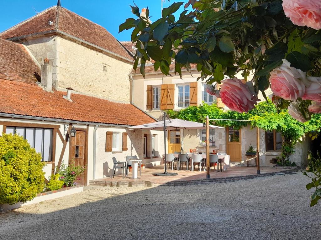 a house with tables and chairs in front of it at Aux Sources de Ouanne in Ouanne