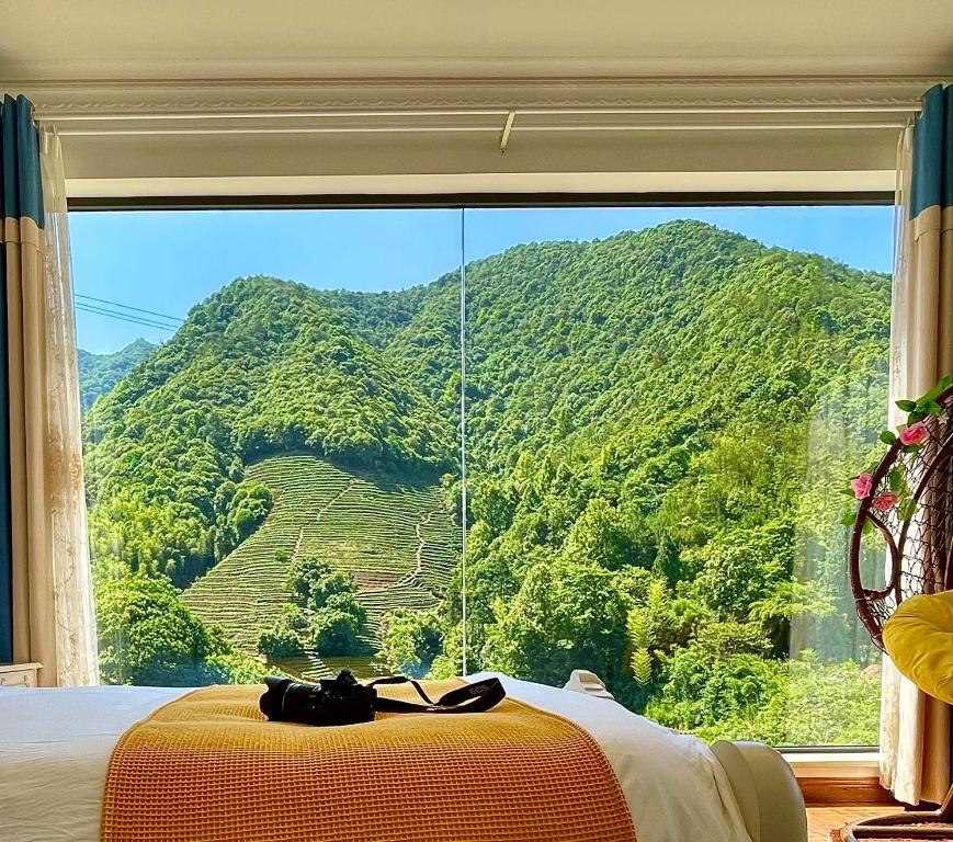 a bedroom with a large window with a view of a mountain at 千岛湖月下民宿 in Liyang