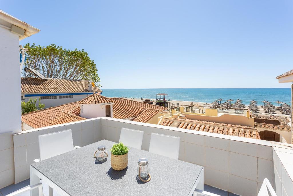 a balcony with a table and chairs and the ocean at Higueron Rental Playa Mira in Benalmádena