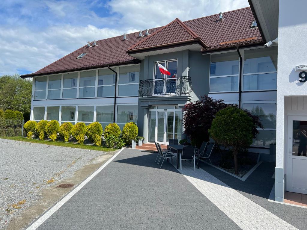 un grand bâtiment avec drapeau sur un balcon dans l'établissement Astoria, à Dąbki