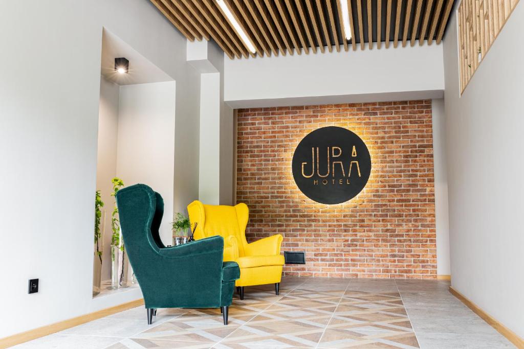 hol z 2 żółtymi krzesłami i ceglaną ścianą w obiekcie Jura Hotel Osiek w mieście Olkusz