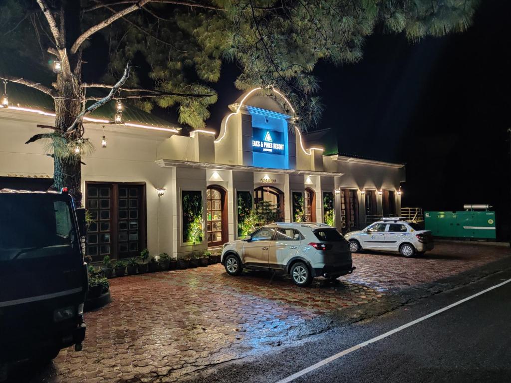 two cars parked in front of a building at night at Peaks And Pines Resort in Lansdowne