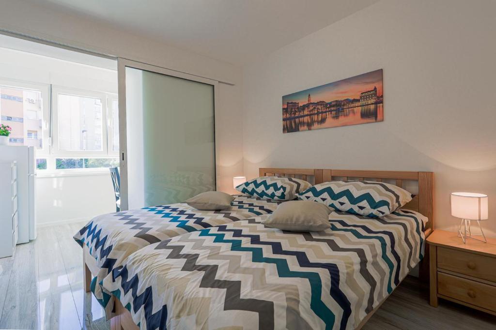 a bedroom with a bed with a striped comforter at Apartman Marica in Split