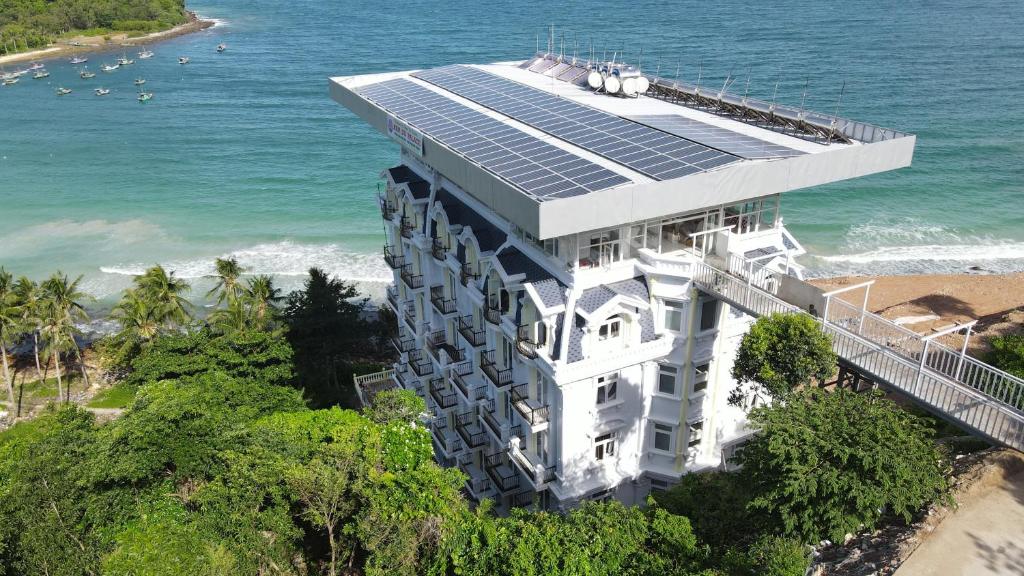 un bâtiment avec des panneaux solaires au-dessus de celui-ci, à côté de l'océan dans l'établissement NAM DU PALACE Hotel, à Nam Du