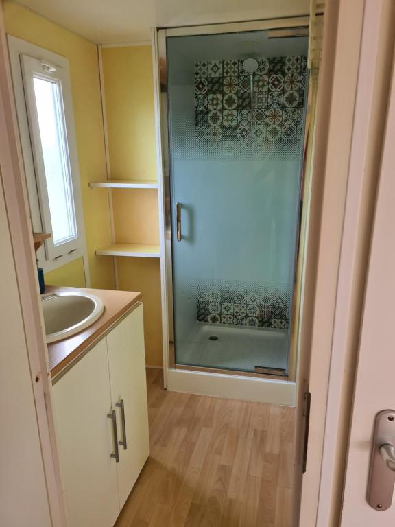 a bathroom with a sink and a glass shower at Casa Prefabricada in El Palmar