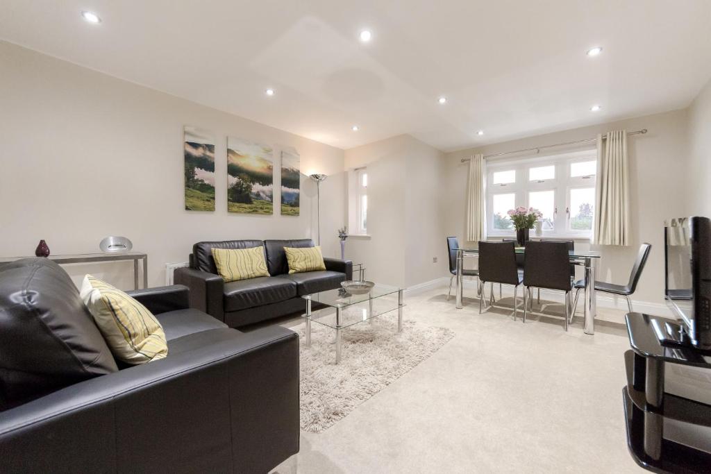a living room with a couch and a dining room at Roomspace Serviced Apartments - Kinnaird Court in Esher