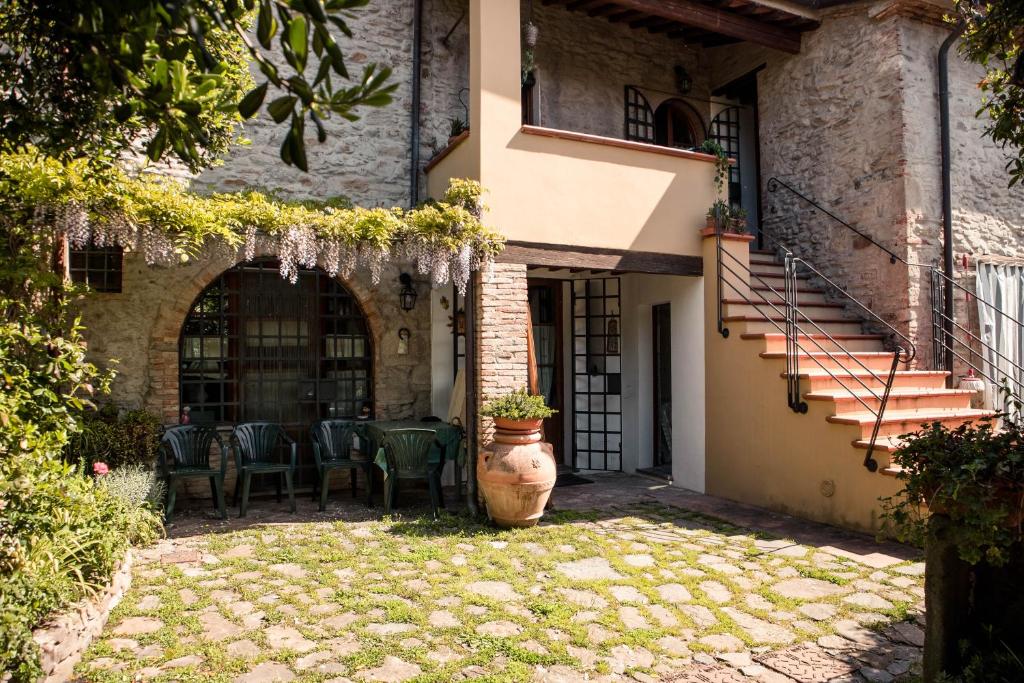 ein Gebäude mit einer Terrasse mit einem Tisch und Stühlen in der Unterkunft Social Garden in Calci