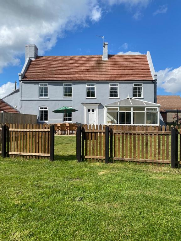 a white house with a wooden fence in front of it at Beautiful newly renovated 5 bedroom farmhouse in Belton