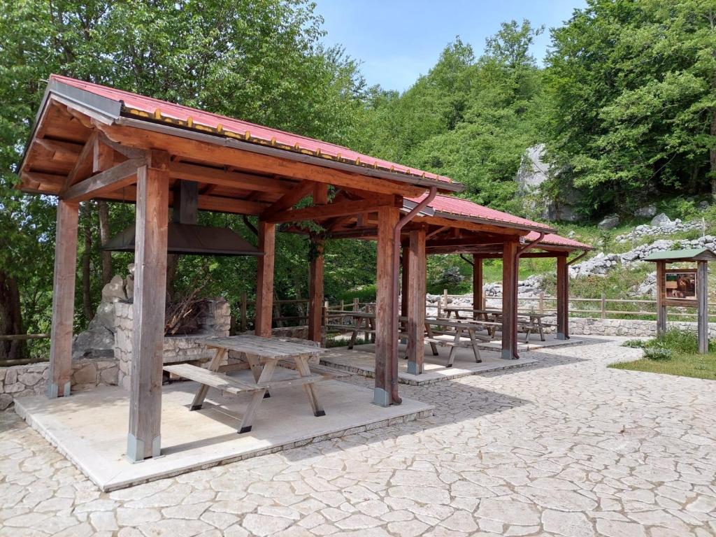 a wooden pavilion with benches and a picnic table at Le Tre Dimore - Rifugio Aceroni in San Biagio Saracinesco