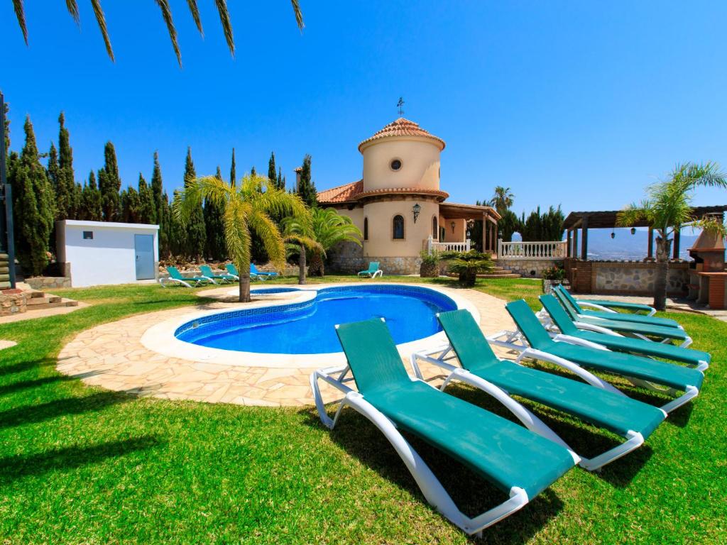 a group of lounge chairs in front of a pool at Holiday Home Villa Pepe by Interhome in Motril
