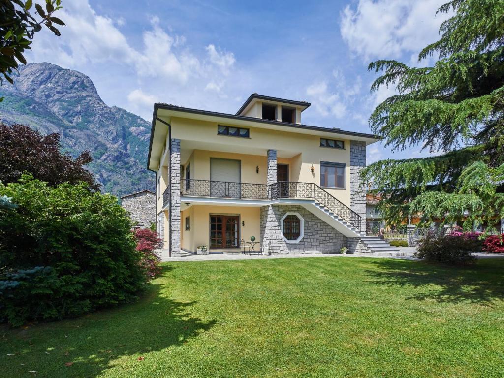 uma vista exterior de uma casa com montanhas ao fundo em Apartment Serena - LMZ180 by Interhome em Riva