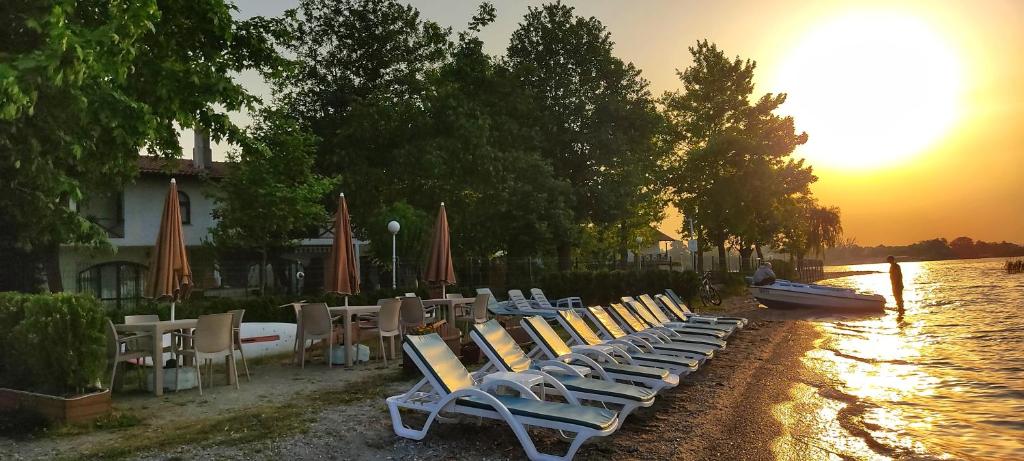 a row of lounge chairs and umbrellas on a river at Senler Boutique Hotel in Sapanca