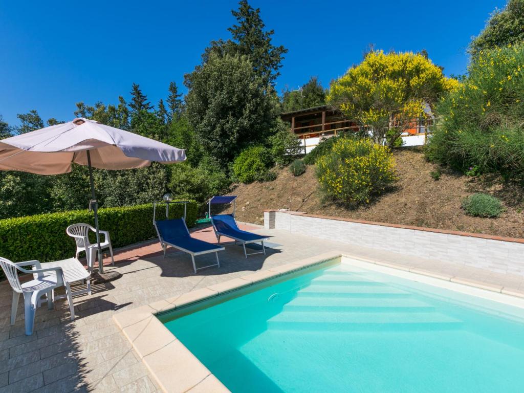 uma piscina com duas cadeiras e um guarda-sol em Holiday Home Il Felciaio by Interhome em Sassa
