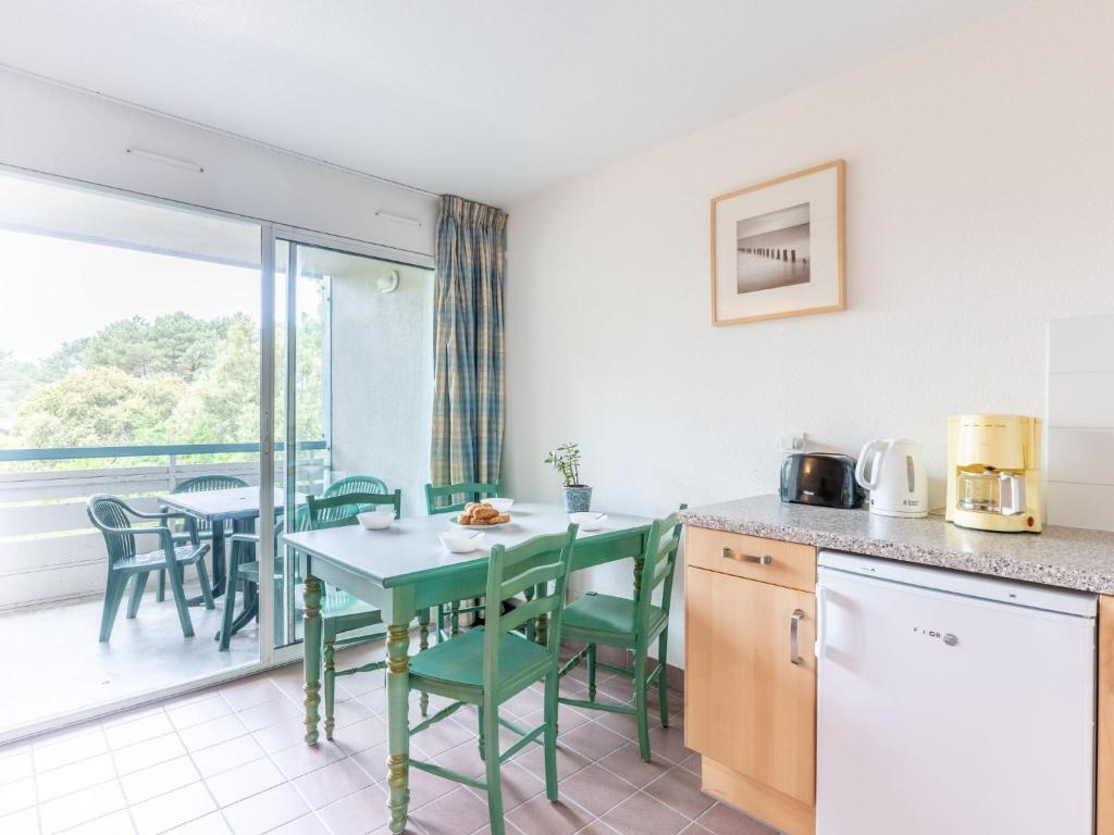 a kitchen and dining room with a table and chairs at Apartment Village Cheval Spa Résidences-6 by Interhome in Lacanau-Océan