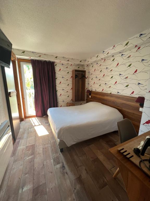 um quarto com uma grande cama branca e uma secretária em Cit'Hotel Le Montreal em Châlons-en-Champagne