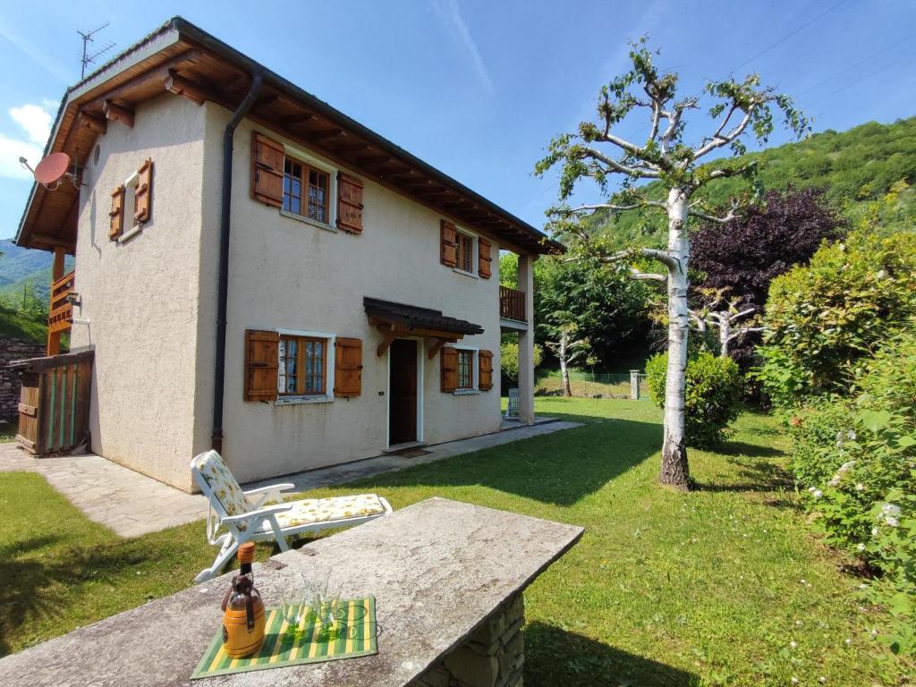 a house with a table and a bottle of wine on it at Holiday Home Irma by Interhome in Porlezza