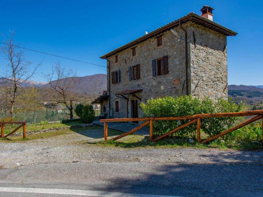 an old stone building with a wooden fence in front of it at Holiday Home Girasole - PZI130 by Interhome in Piazza al Serchio