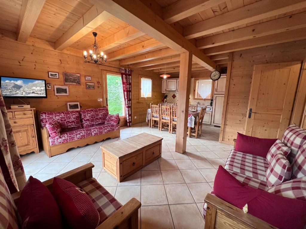 un soggiorno con divano e tavolo in una cabina di L'Aulp De Suz 1 - Demi chalet a La Clusaz