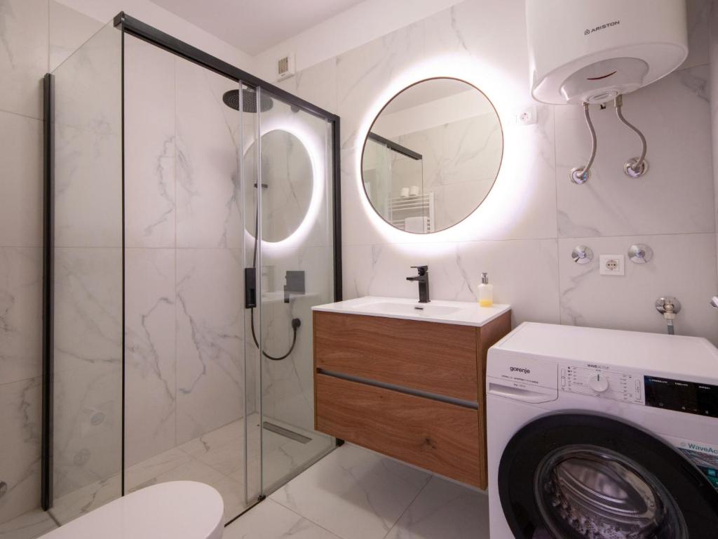 a bathroom with a washing machine and a mirror at Holiday Home Villa Orhidea by Interhome in (( Marčići ))