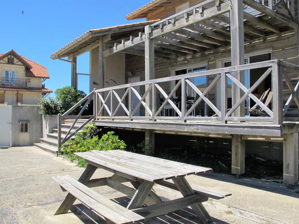 a wooden picnic table sitting in front of a building at Holiday Home Villa Marine by Interhome in Mimizan-Plage