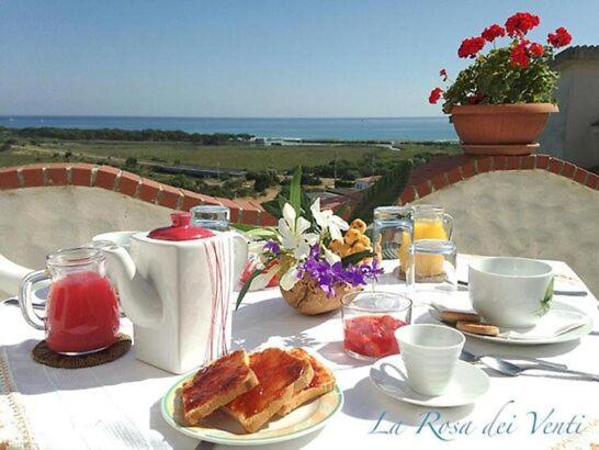 un tavolo con colazione a base di tè e pane tostato di La Rosa dei Venti a La Caletta