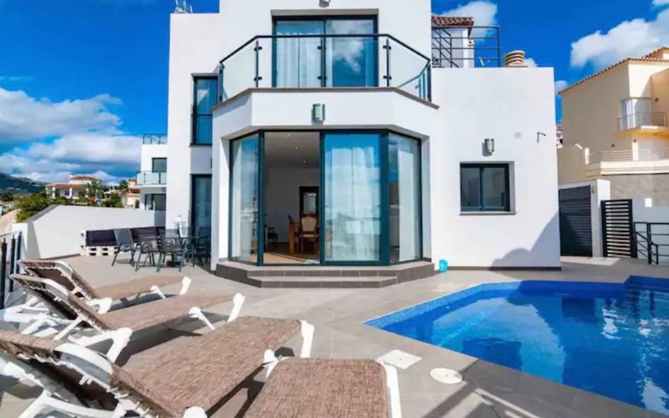 eine Villa mit einem Pool und einigen Stühlen in der Unterkunft Villa Torre Paraíso in Torrox