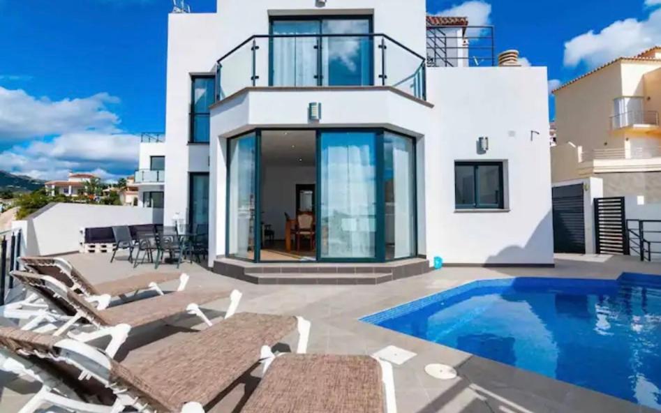 a villa with a swimming pool and some chairs at Villa Torre Paraíso in Torrox