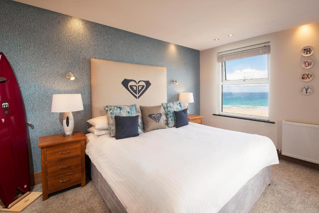 a bedroom with a large white bed with a window at Esplanade Hotel in Newquay