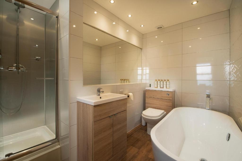 a bathroom with a tub and a sink and a toilet at Esplanade Hotel in Newquay