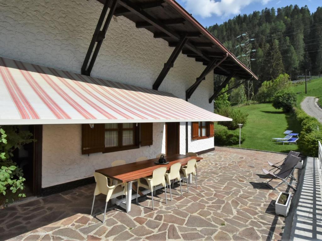 a patio with a wooden table and chairs in front of a building at Villa Villa Lucia by Interhome in Pellizzano