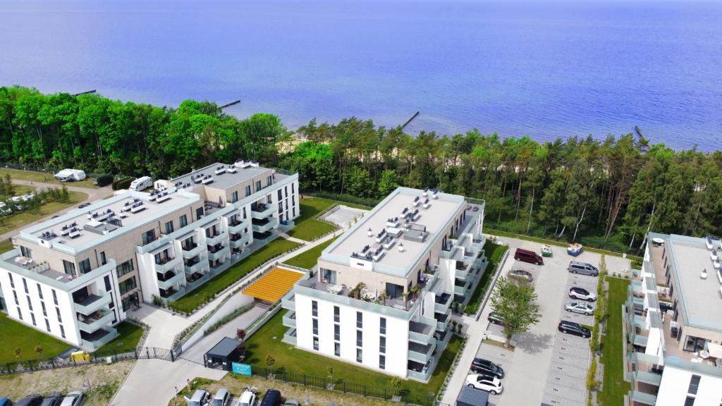 une vue de tête sur deux bâtiments blancs et l'océan dans l'établissement VOJCAR Apartments, à Rewal
