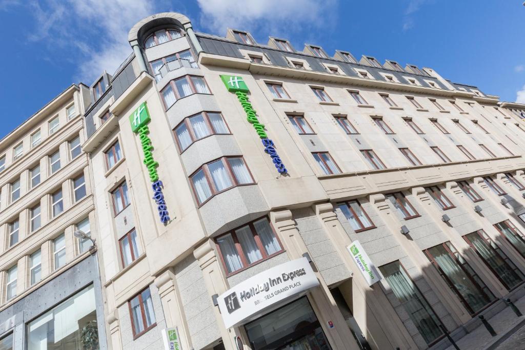 a tan building with green words on it at Holiday Inn Express Brussels-Grand-Place, an IHG Hotel in Brussels