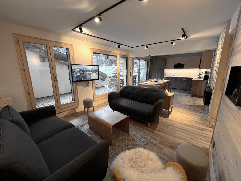 a living room with a couch and a table at BOREAL Bel appartement village et pistes in La Clusaz