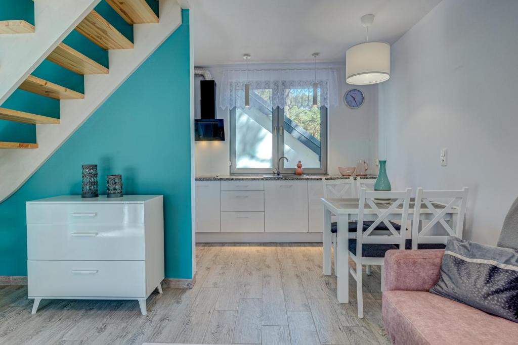 uma cozinha e sala de estar com uma escada e uma mesa em PROFIL Family House em Pogorzelica