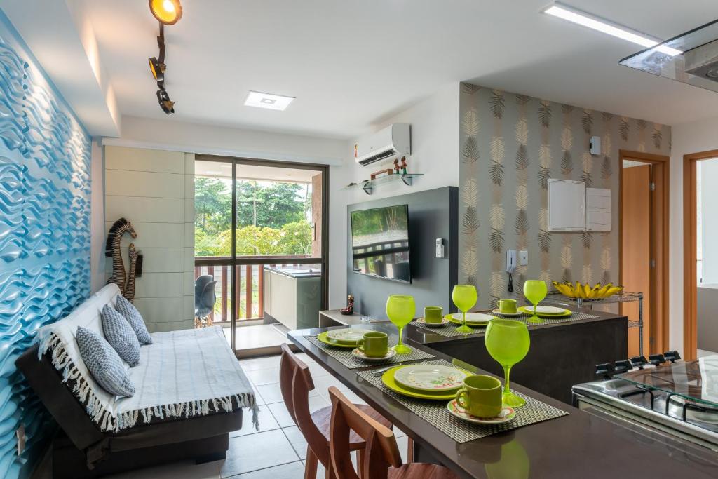 uma cozinha e sala de estar com mesa e cadeiras em vemproCUPEPORTODEGALINHAS Casal ou Família no melhor apartamento de Porto de Galinhas em Porto de Galinhas