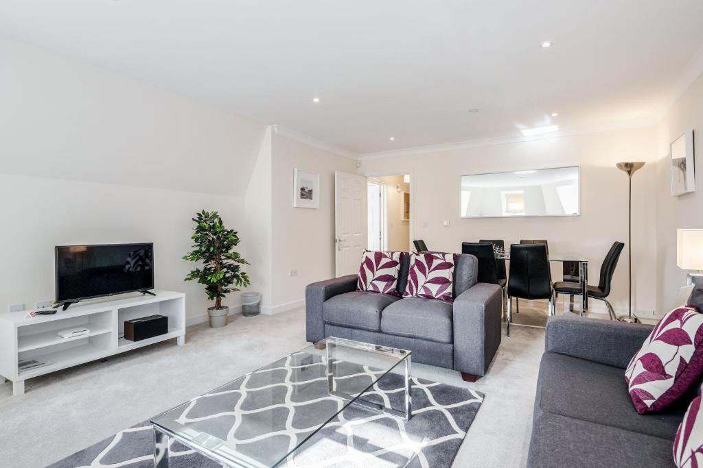 uma sala de estar com um sofá e uma televisão em Roomspace Serviced Apartments - Royal Swan Quarter em Leatherhead