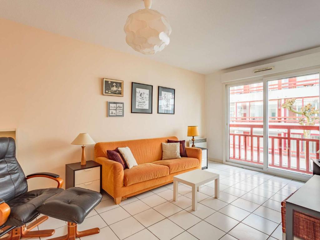 - un salon avec un canapé et des chaises orange dans l'établissement Spacieux Appartement 3* à Saint-Jean-de-Luz avec Parking, Terrasse et Proximité Commerces - FR-1-4-516, à Saint-Jean-de-Luz