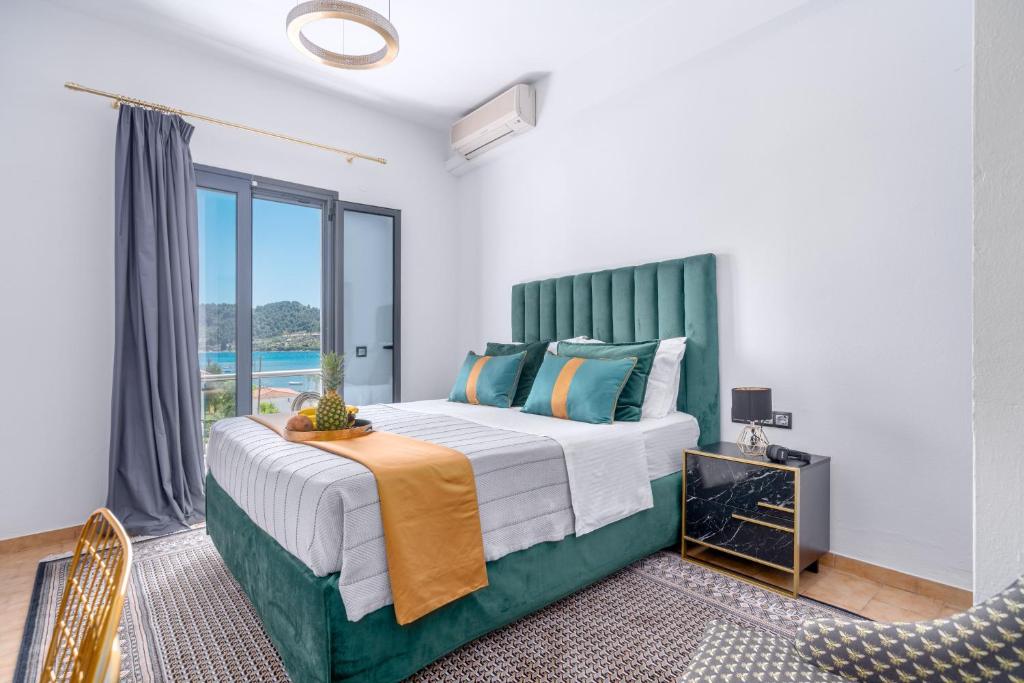 een slaapkamer met een groot bed met een groen hoofdeinde bij MR P. Boutique Residence in Skiathos-stad