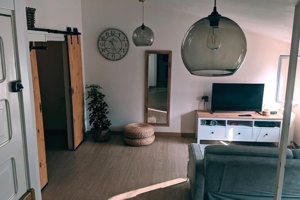 ein Wohnzimmer mit einem Sofa und einem TV in der Unterkunft Ático encantador... in A Coruña