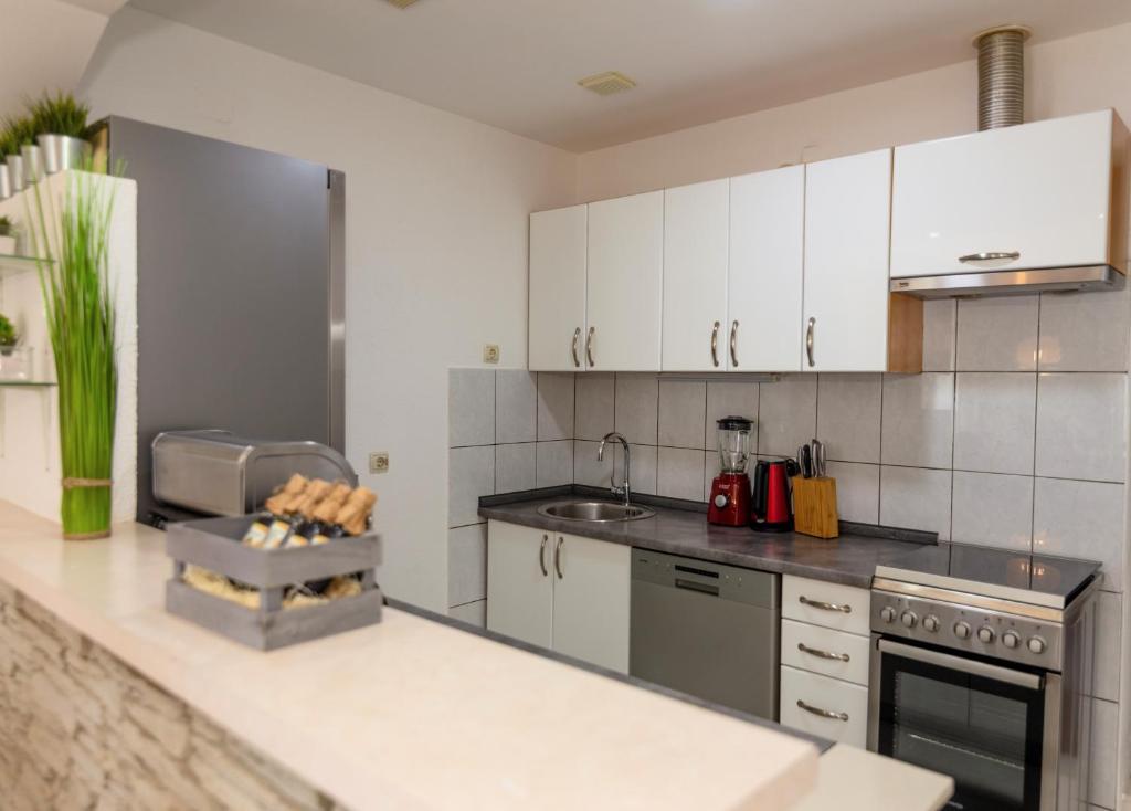 a kitchen with white cabinets and a counter top at Villa Prima Natura, Imotski private pool in Imotski