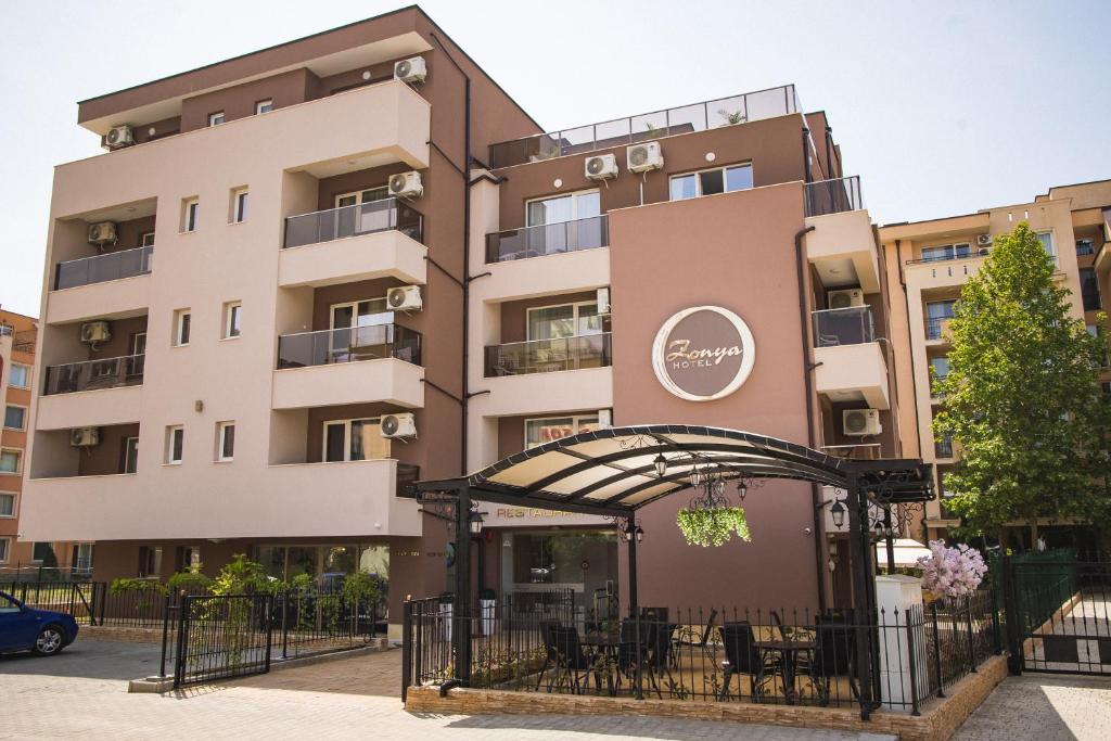 ein Apartmenthaus mit einem Restaurant davor in der Unterkunft Hotel Zonya in Sonnenstrand