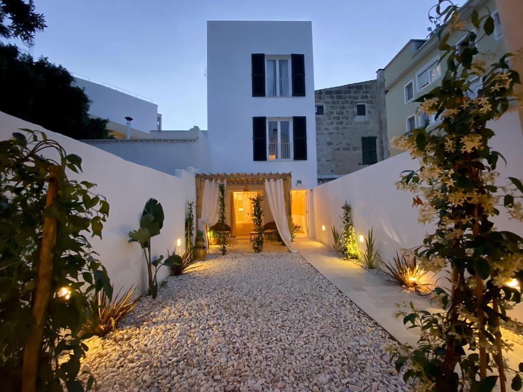 een pad naar een wit gebouw met verlichting bij 120 Hotel Boutique - Adults Only in Ciutadella